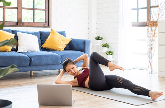 Home workout - vrouw traint thuis met video instructie.