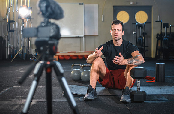 Online fitness-studio: fitness instructeur bereidt een fitness cursus online voor.