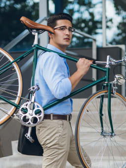 Mit dem Fahrrad zur Arbeit: Mann trägt sein Fahrrad die Stufen hinauf.