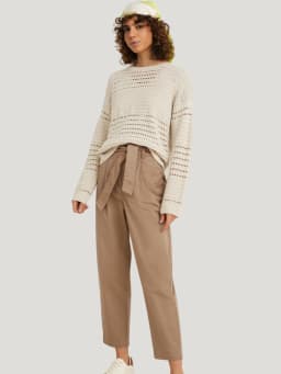 Tenue de voyage : pantalon en tissu décontracté avec pull léger.