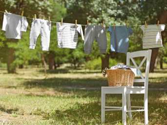 Babykleidung auf Wäscheleine in der Sonne - die UV-Stahlen sollen nach dem Baby-Kotflecken-Entfernen letzte Reste ausbleichen Babykleidung auf Wäscheleine in der Sonne - die UV-Stahlen sollen nach dem Baby-Kotflecken-Entfernen letzte Reste ausbleichen