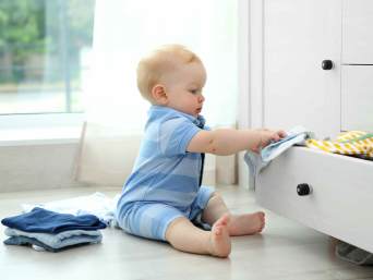 Baby spielt mit Kleidung 