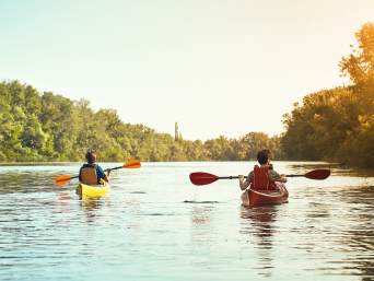 Wasserwandern – Zwei Wasserwanderer fahren auf einem Fluss. 
