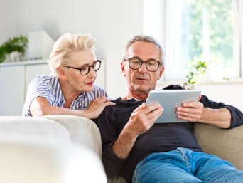 Koníčky pro důchodce: Senioři se společně dívají na tablet.