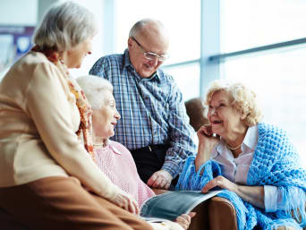 Geheugentraining: senioren zitten samen op een bank en vermaken zich.
