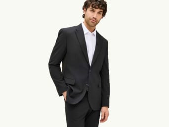 Abito nero da uomo – Un uomo indossa un completo nero.