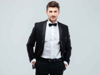 Vlinderdas strikken: man draagt een zwarte vlinderdas bij een zwart pak. Vlinderdas strikken: man draagt een zwarte vlinderdas bij een zwart pak.