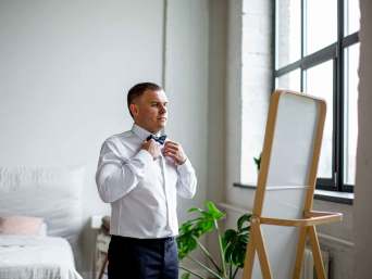 Vlinderdas strikken makkelijk gemaakt: man in een zwart pak met bijpassende vlinderdas. Vlinderdas strikken makkelijk gemaakt: man in een zwart pak met bijpassende vlinderdas.