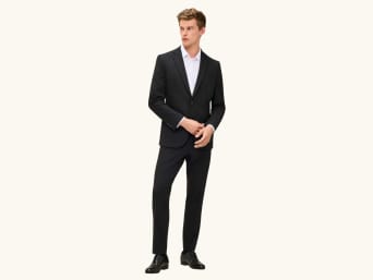 Muž má na sobě pánský oblek slim fit. Muž má na sobě pánský oblek slim fit.