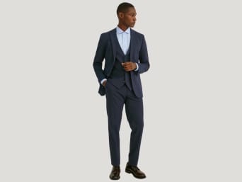 Tipos de traje para hombre: un hombre lleva un traje slim fit con un chaleco.