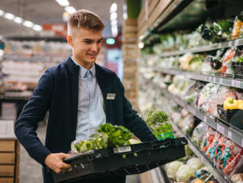 Was ist eine duale Ausbildung?  – Auszubildender absolviert eine Ausbildung als Einzelhandelskaufmann im Supermarkt.