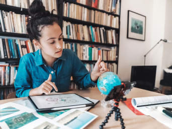 Anerkennung Auslandsjahr – Schülerin lernt mit Tablet und Globus.