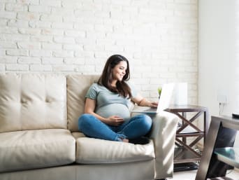 Una donna incinta si documenta sulle regole per scegliere i nomi per bambini.