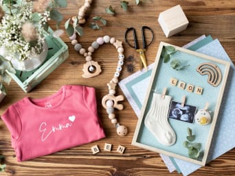 Marco de fotos para bebé: diseña uno con ropa, colgantes para cochecitos y el nombre del bebé.