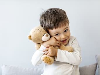 Spielzeug Kinder – Junge kuschelt mit seinem Teddy.
