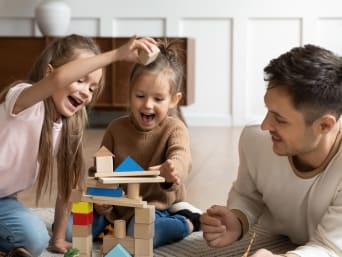 Un jeu pédagogique : une famille joue avec des blocs de construction.