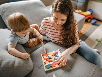 Nachhaltiges Spielzeug – Mutter und Sohn spielen mit einem Holz-Puzzle.