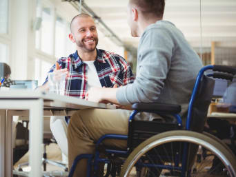 Jonge professional - man in een rolstoel tijdens een sollicitatiegesprek.