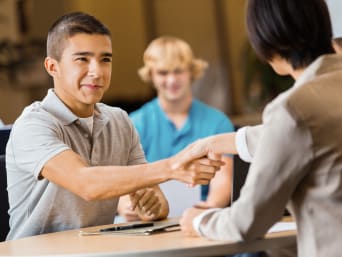Schülerpraktikum Bewerbung: Schüler wird im Vorstellungsgespräch von Personaler begrüsst.