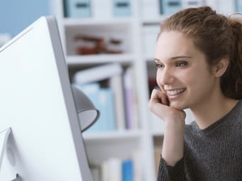 Bewerbungsknigge – Junge Frau sitzt am PC und bereitet sich auf die Jobsuche vor.