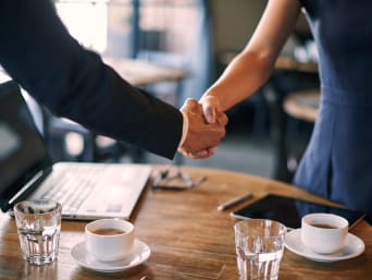 Come presentarsi ad un colloquio: due persone si stringolo la mano ad un colloquio di lavoro.