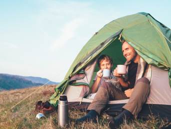 Zelten-Checkliste: Vater und Sohn entspannen im Zelt.