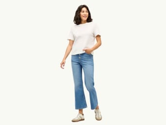 Co jsou to bootcut džíny – Žena má na sobě bootcut džíny a černé tílko. Co jsou to bootcut džíny – Žena má na sobě bootcut džíny a černé tílko.
