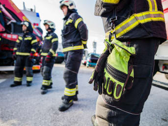 Wolontariat w Ochotniczej Straży Pożarnej – zebrani strażacy przed wozem strażackim.