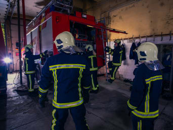 Vrijwillige brandweer: brandweerlieden bereiden brandweerauto voor om te vertrekken.