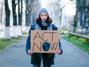 Volontario per la protezione dell’ambiente: una giovane manifestante mostra un cartello per la salvaguardia dell’ambiente. 