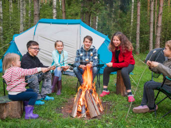 Feriencamp – Kinder grillen Marshmallows über einem Lagerfeuer.