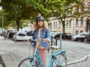 Bike sharing: una donna va al lavoro con una bicicletta a noleggio.