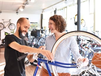 Waar moet je op letten als je een fiets koopt: vrouw krijgt advies in een speciaalzaak.