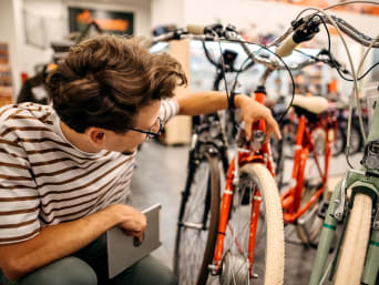 Acheter un vélo : un homme vérifie l’équipement d’un vélo avant de l’acheter. 