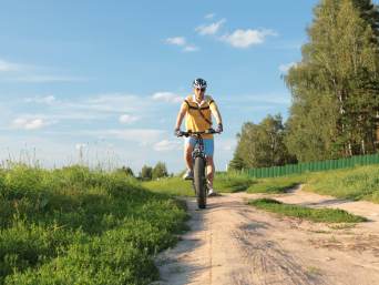 Tips voor een geslaagd fietsavontuur in Friesland: man fietst over een onverhard pad in de natuur.