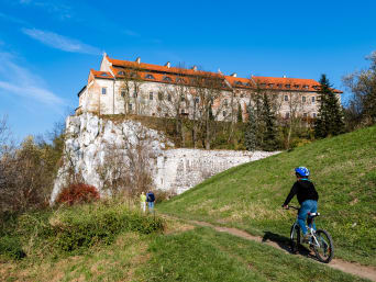 Szlaki rowerowe Małopolska – rodzina z dzieckiem na rowerze podjeżdża pod klasztor w Tyńcu. Szlaki rowerowe Małopolska – rodzina z dzieckiem na rowerze podjeżdża pod klasztor w Tyńcu.