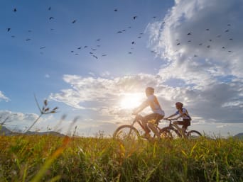 Lubuskie rowerem: tata z synem podziwiają ptaki w Parku Narodowym Ujście Warty. 