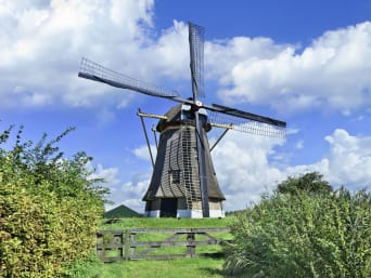 Brabantse Walroute: Een oud-Hollandse molen, omgeven door een deels blauwe lucht en natuur. 