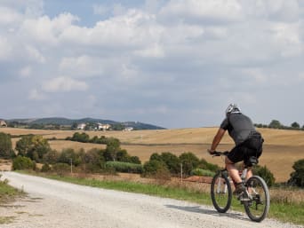 Umbria in bici: un uomo pedala su una strada sterrata in Umbria.