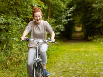 Bloesem fietsroute: Meisje fietst door de natuur. 