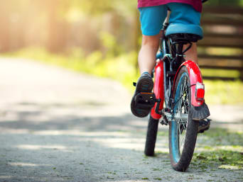 Bicicletas seguras para niños: detalle de un niño pedaleando en una bicicleta.
