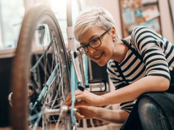 Une jeune femme vérifie la sécurité de son vélo et de l’équipement obligatoire.