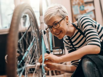 Fiets veiligheidscheck: vrouw test of haar fiets nog verkeersveilig is.