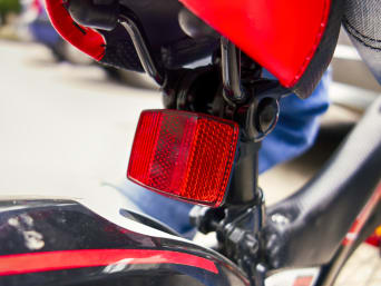 Fahrradbeleuchtung: Ein Rückstrahler an der Rückseite des Fahrrads ist in Großaufnahme zu sehen.