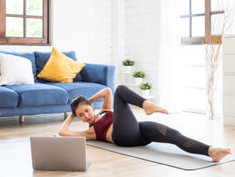 Home workout - vrouw traint thuis met video instructie.