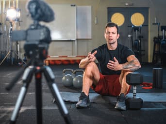 Online gym: Fitness instructor setting up for an online fitness lesson.