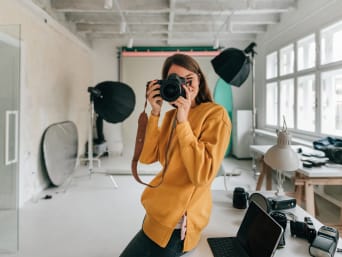 Different types of photography – a photographer taking photos in a photo studio. 