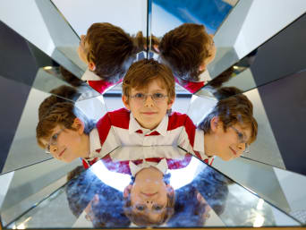 Bambini al museo - bambino in un museo prova un esperimento ottico.