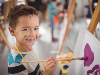 Warsztaty artystyczne dla dzieci – chłopiec maluje na zajęciach plastycznych.