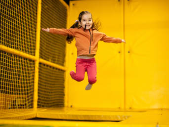 Sportieve uitjes - klein meisje springt op een trampoline.